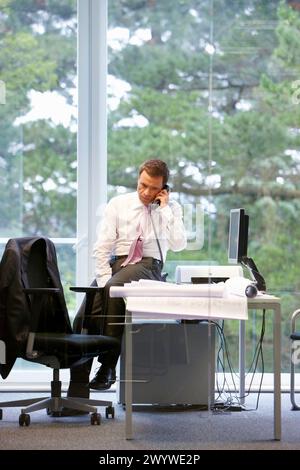 Architect with blueprints in office. Stock Photo