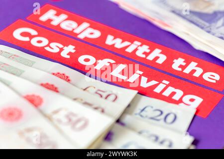 A Government leaflet of help with the cost of living and various bank notes. A poverty, cost of living concept. Stock Photo