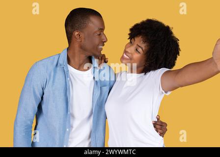 Young couple taking a selfie together on yellow Stock Photo