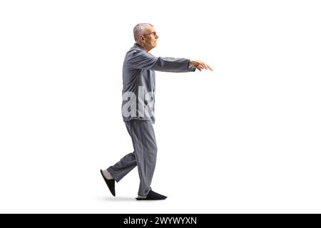 Full length profile shot of a senior man in pajamas sleepwalking isolated on white background Stock Photo