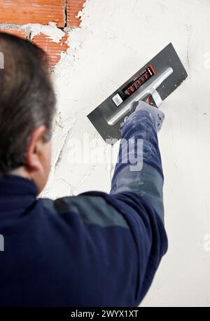 Rendering a brick wall using trowel, new homes under construction, construction site. Stock Photo