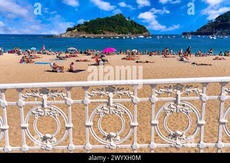 Bañistas en la Playa de Ondarreta, detrás la Isla Santa Clara, Donostia, San Sebastian, Ciudad cosmopolita de 187.000 habitantes, destaca por su gastronomía, playas urbanas y edificios inspirados en la arquitectura parisina, Gipuzkoa, Basque Country, Spain, Europe. Stock Photo