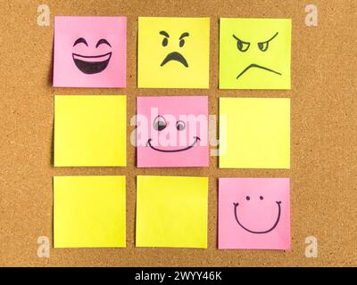cork board with colorful post its representing various emoticons with various emotions communication concept Stock Photo