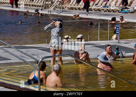 Glenwood Springs, Colorado, USA. 8 April 2024. Bathers in the historic Glenwood Hot Springs Pool, the largest hot springs swimming pool in the world, view the solar eclipse from the Rocky Mountains. Credit: Kristin Cato/Alamy Lives News Stock Photo