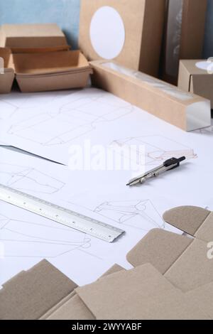Creating packaging design. Drawings, boxes and stationery on table ...