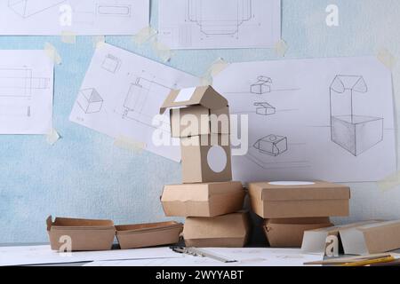 Creating packaging design. Drawings, boxes and stationery on table ...