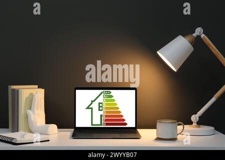Energy efficiency rating on laptop display. Workplace with modern computer Stock Photo