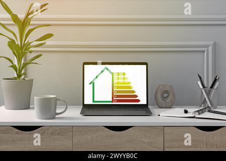 Energy efficiency rating on laptop display. Workplace with modern computer Stock Photo