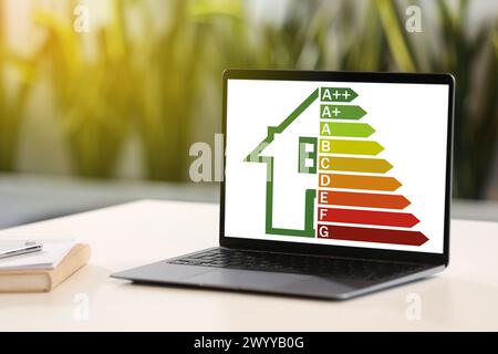 Energy efficiency rating on laptop display. Workplace with modern computer Stock Photo