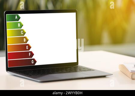 Energy efficiency rating on laptop display. Workplace with modern computer Stock Photo