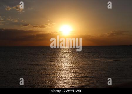 Sun setting over the ocean Stock Photo