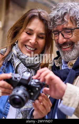 Close up smiling retired couple holding looking at camera photos. Mature pensioner tourist people.  Stock Photo
