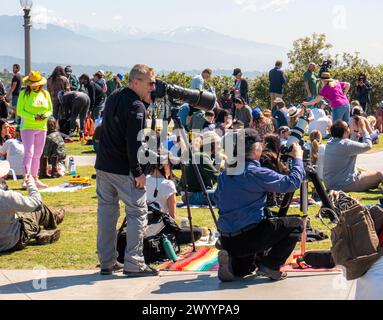 Two men with cameras and telescopes with solar filters watching the 2024 solar eclipse in Los Angeles, California, United States, on April 8, 2024. Stock Photo