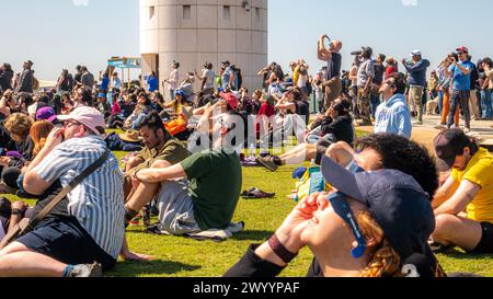 A crowd of people watching the 2024 solar eclipse in front of Griffith ...