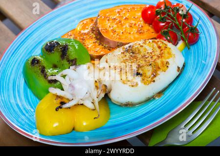 Sepia fried on a grill with Bulgarian pepper and boiled batat is tasty dish Stock Photo