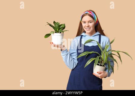 Pretty young woman with houseplants on beige background Stock Photo