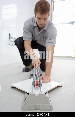 Bricklayer cutting tile. Manual tile cutter. Construction Industry. Stock Photo
