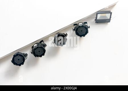 A set of spotlights hanging from the ceiling above the stage Stock Photo