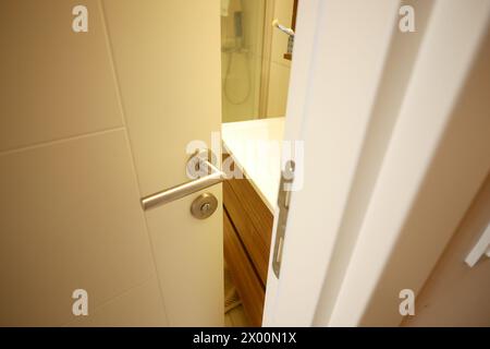 gray bathroom door slightly open . Stock Photo