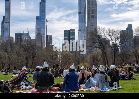 New York, United States. 08th Apr, 2024. People wearing tin foil hats enjoy the eclipse with a city skyscraper view facing south. New Yorkers gathered in Central Park to view the solar eclipse. The sun was eclipsed by the moon by 90%, just shy of totality. The last solar eclipse in New York City was in 2017 reaching 70%. The next solar eclipse for the city will be in 2045 at only 50%. New Yorkers will have to wait until May, 2079 for totality. Credit: SOPA Images Limited/Alamy Live News Stock Photo