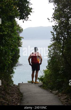 A hiker enjoying the views from the MacLehose Trail Section 2 at the Sai Kung East country park in Hong Kong. Stock Photo