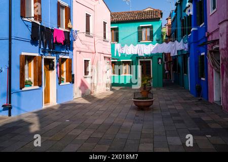 Colourfully painted houses with laundry put up on washing lines on the island of Burano. Stock Photo