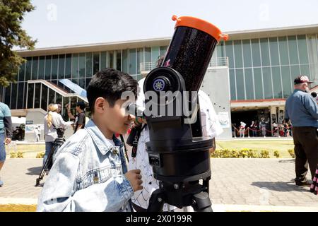 Non Exclusive: A person  observes the solar eclipse through a telescope during the Great North American Solar Eclipse in Mexico City, Mexico. Persons Stock Photo