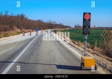 Traffic light signalization during road maintenance, red stoplight for traffic regulation, selective focus Stock Photo