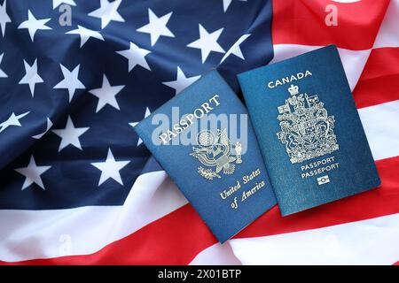 Passport of Canada with US Passport on United States of America folded flag close up Stock Photo