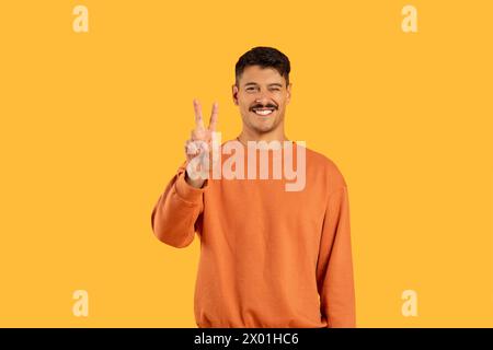 Man with moustache showing peace sign with fingers Stock Photo