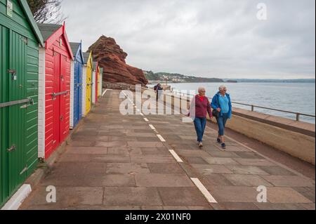 Colourful beach huts on the promenade along the seawall close to Boat Cove, Dawlish, Devon, England, UK, on a grey autumnal day. Stock Photo