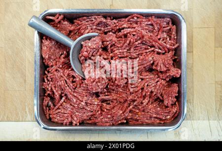 beef mince meat in metal container on butchers table Stock Photo
