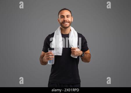 Smiling man with towel and water bottle Stock Photo