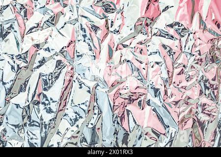 Abstract Texture of Crumpled Metallic Foil in Shades of Pink and Silver Stock Photo