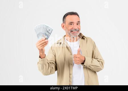 Happy man holding cash and giving thumbs up Stock Photo