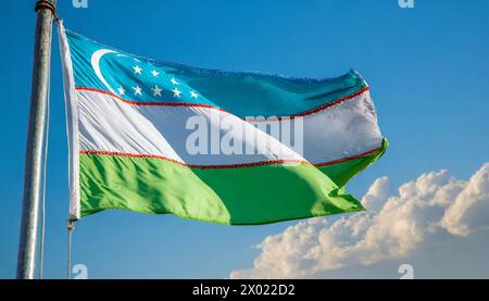 Fahnen, die Nationalfahne von Usbekistan flattert im Wind Stock Photo