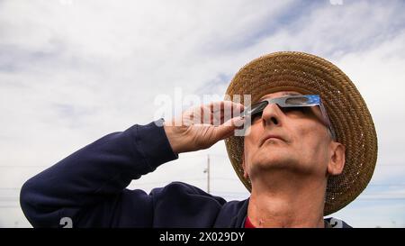 NORWALK, CT, USA - APRIL 8, 2024: Man is watching American eclipse with protective glasses Stock Photo