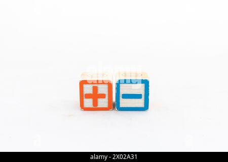 Wooden blocks showing plus and minus signs isolated on white background Stock Photo