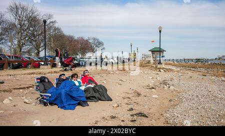 NORWALK, CT, USA - APRIL 8, 2024: Calf Pasture Beach in Norwalk with peoples watchimg American eclipse Stock Photo