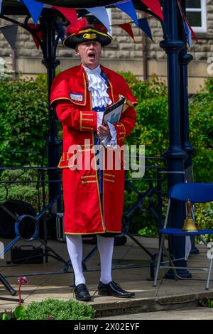 Male town crier (colourful crier's uniform, loud voice) proclaiming, making public proclamation & announcement - Ilkley, West Yorkshire, England, UK. Stock Photo