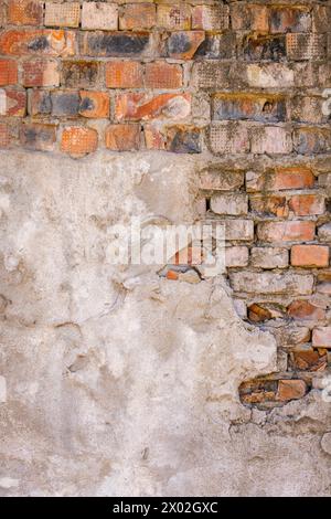 Detailed closeup texture of a brick wall with plaster leftovers Stock Photo