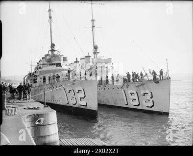 THE ARRIVAL OF THE FIRST FLOTILLA OF DESTROYERS FROM AMERICA TO THE ROYAL NAVY, DEVONPORT, SEPTEMBER 1940 - Two destroyers, HMS CASTLETON (formerly American Wikes Class destroyer USS AARON WARD) and HMS CLARE (formerly Clemson Class, USS ABEL P UPSHER), sit moored alongside each other alongside the Devonport Dockyard, September 1940. They still show their US Navy pennant numbers. .Dockyard workers are aboard preparing the ships for service in the Royal Navy  Royal Navy, HMS Castleton, Destroyer, (1919), Royal Navy, HMS Clare, Destroyer, (1918) Stock Photo