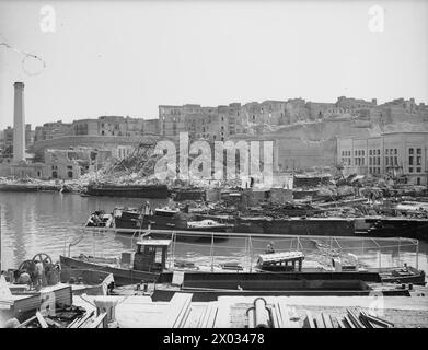 BOMB DAMAGE IN MALTA AFTER BIGGEST RAID YET. 7 APRIL 1942. BOMB DAMAGE TO THE DOCKYARDS. - Looking across to all that remains of the saw mills, an old generating station Stock Photo