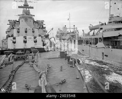 CRUISER REFUELLING AT SEA. SEPTEMBER 1944, ON BOARD HMS JAMAICA AT SEA, REFUELLING FROM A TANKER. - Looking aft as the ships proceed with refuelling still in progress. In the foreground is a rating holding a marked line which enables the navigator watching from the bridge to keep a true course during the operation Stock Photo