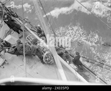 CRUISER REFUELLING AT SEA. SEPTEMBER 1944, ON BOARD HMS JAMAICA AT SEA, REFUELLING FROM A TANKER. - The hoses about to be passed through a trough Stock Photo