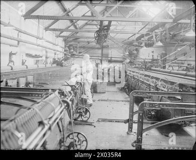HUDDERSFIELD CLOTH MILL: THE WORK OF C & J HIRST AND SONS LTD., SUNNYBANK, LONGWOOD, HUDDERSFIELD, YORKSHIRE, ENGLAND, UK, 1943 - Mill workers man large yarn spinning machines at the mill of C and J Hirst and Sons Ltd. in Huddersfield. These machines spin wool into yarn, which will then be woven into cloth Stock Photo
