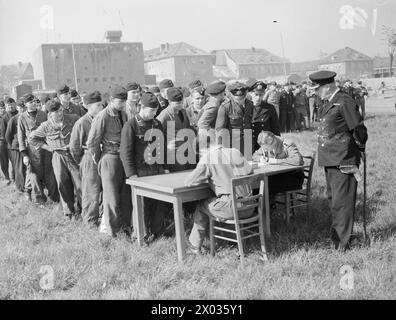 THE NAVY TAKES OVER AT KIEL. 6 TO 12 MAY 1945, THE GERMAN NAVAL BASE AT KIEL AFTER THE ROYAL NAVY HAD TAKEN IT OVER. - Cdr Sheridan Patterson RN (right) watching the listing of names and numbers of German U-boat crews who lined up near their barracks. German personnel took the information under the suoervision of British Naval Officers , Stock Photo