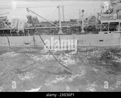 CRUISER REFUELLING AT SEA. SEPTEMBER 1944, ON BOARD HMS JAMAICA AT SEA, REFUELLING FROM A TANKER. - The line secured to double hoses which are hauled to the cruiser Stock Photo