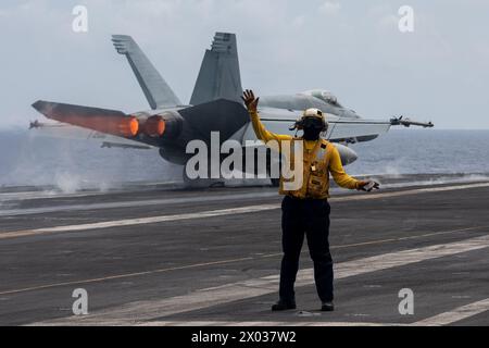 PHILIPPINE SEA (April 8, 2024) U.S. Navy Aviation Boatswain’s Mate 1st Class Michael Joseph, from Carrollton, Ga., signals aircraft as an F/A-18E Supe Stock Photo