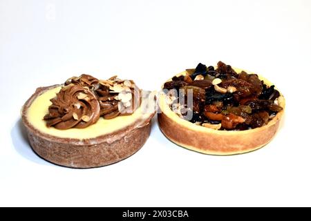 Two round cake baskets, with cottage cheese, cream, raisins and nuts on a white background. Stock Photo